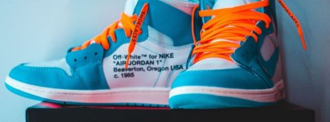 Qui sont les conso'tradeurs ? Une paire de baskets Nike bleue turquoise avec des lacets orange