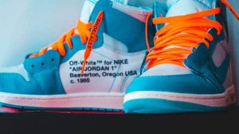 Une paire de baskets Nike bleue turquoise avec des lacets orange