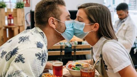 Deux adolescents qui s'embrassent avec des masques chirurgicaux