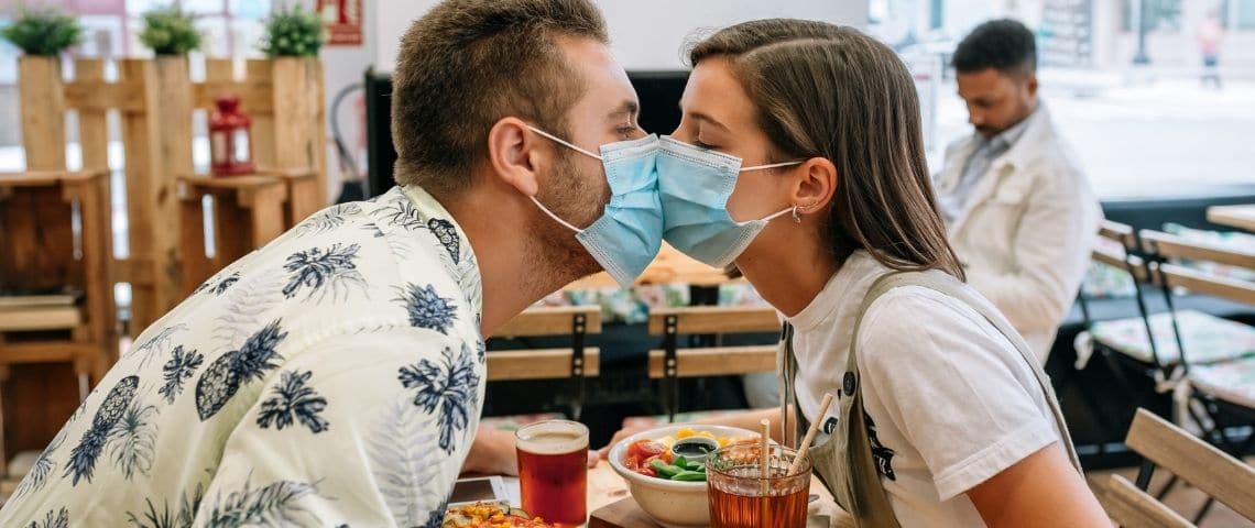 Etude tinder : comment les Z font des rencontres pendant la pandémie ? Deux adolescents qui s'embrassent avec des masques chirurgicaux