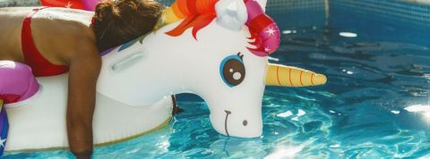 Quelles sont les contraintes du digital nomadisme ? Une personne fatiguée sur une bouée licorne dans une piscine
