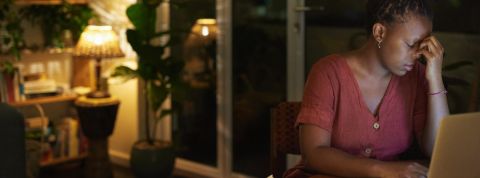 Dans la tech, les femmes sont davantage harcelées en télétravail Une femme l'air épuisée travaille sur son ordinateur dans un salon