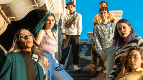 6 adolescents en tenues colores prennent la pose sur un escalier