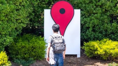 Un homme devant le logo de Google Maps