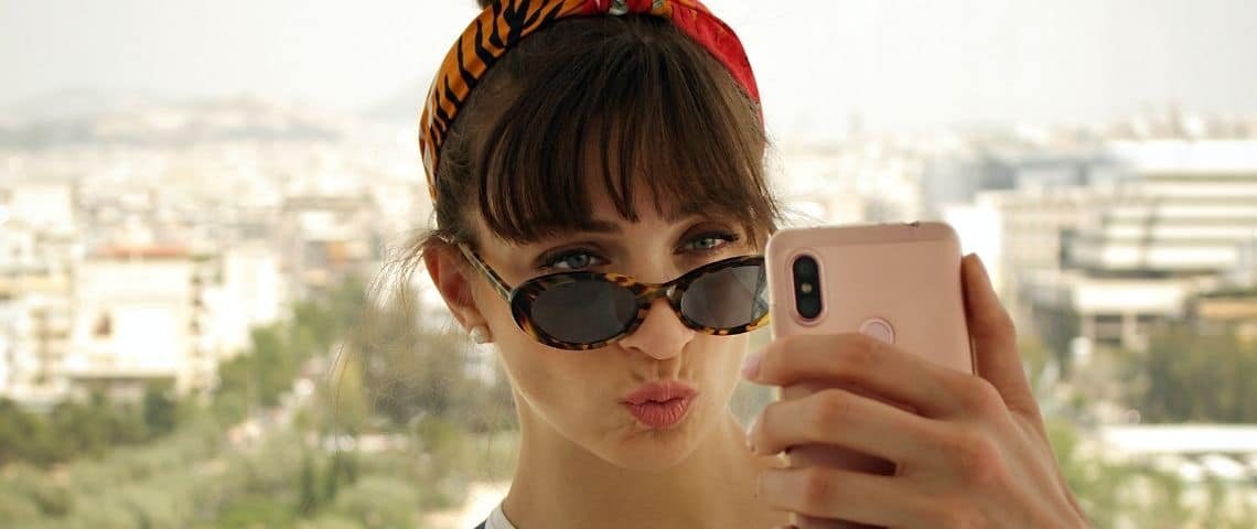 Le travel shaming sur Instagram Une femme qui prend un selfie