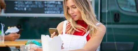 Quelles sont les marques préférées des millennials qui cartonnent sur Instagram ? Une femme en train de prendre son sandwich en photo avec son smartphone