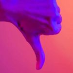 Une main en train de baisser son pouce sur un fond coloré