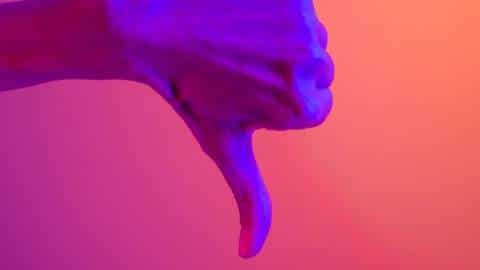 À quoi devaient servir les NFT à l'origine ? Une main en train de baisser son pouce sur un fond coloré