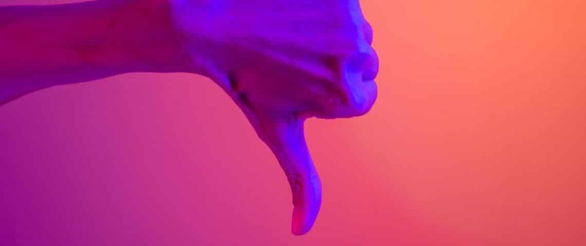 À quoi devaient servir les NFT à l'origine ? Une main en train de baisser son pouce sur un fond coloré