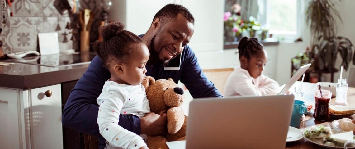 Comment devenir un manager empathique ? Un papa en train de s'occuper de ses deux petites filles en télétravail