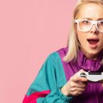Jeune fille blonde à lunettes et joystick dans les mains
