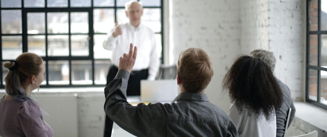 Seo-local-referencement-pratiques-optimisation Cinq adultes dans une classe. Un lève la main
