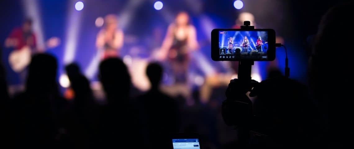 Dooweet-musique-streaming-plateforme-reseaux-sociaux-visibilité-artistes-rentabilité-fanbase Concert avec un téléphone qui filme