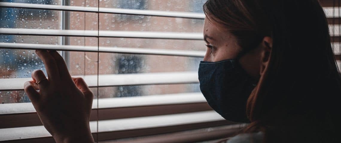 lalliance-digitale-contre-la-covid-19-plateforme-coronapsy-depression-anxiété-aide-spychologique-spychologie-spychologue-spychiatre Une femme avec un masque qui regarde par la fenêtre