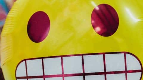 Un ballon de l'emoji qui grimace les dents serrés