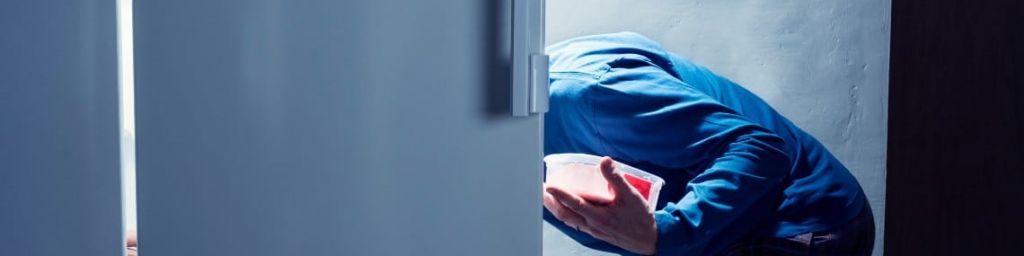 Un homme se sert dans un frigo la nuit