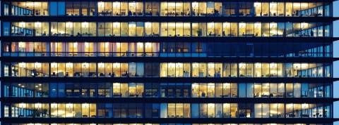 Un immeuble le soir aux fenêtres éclairés