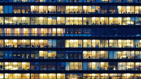 Un immeuble le soir aux fenêtres éclairés