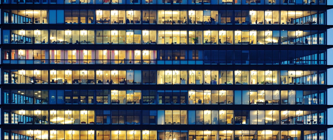 Un immeuble le soir aux fenêtres éclairés