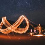 Un sigle infini dessiné en lumière par des personnes dans le désert