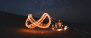 Un sigle infini dessiné en lumière par des personnes dans le désert