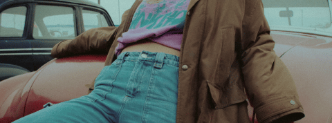 Z contre Y : tout se joue autour du jean! Une fille en jean appuyée contre une voiture rouge