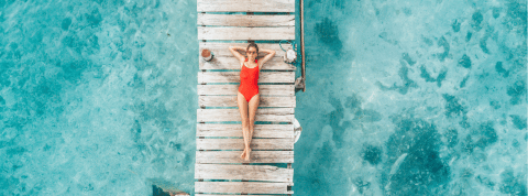 Nos smartphones sont nos nouvelles maisons Une femme en maillot de bain rouge bonze sur un ponton vue du ciel