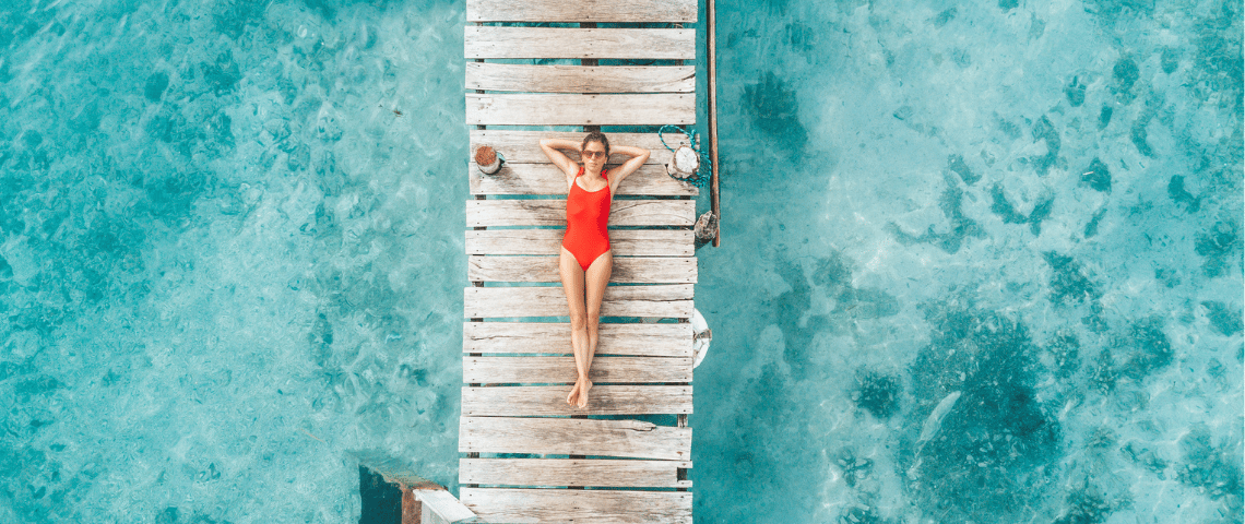 Nos smartphones sont nos nouvelles maisons Une femme en maillot de bain rouge bonze sur un ponton vue du ciel