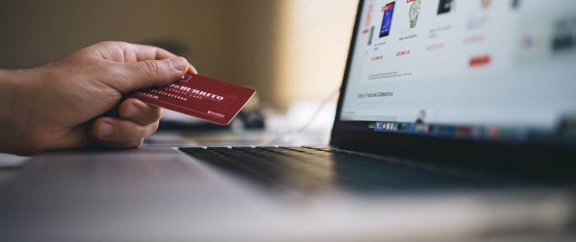Shopify met à disposition un générateur de noms de domaine en .fr et les conseils de l’Afnic pour renforcer la présence en ligne des entreprises Carte de paiement devant un ordinateur