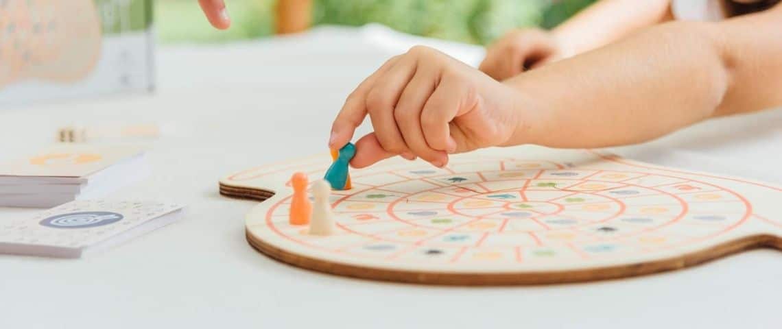 Sloli, basée à Roubaix, sensibilise les 4-12 ans aux enjeux environnementaux. Enfant déplaçant un pion sur un plateau de jeu en bois