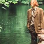 Un home-poisson en costume debout dans l'eau