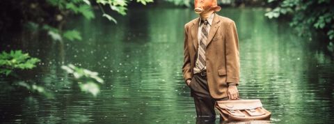 Une entreprise fait croire à un faux bonus pour sensibiliser ses équipes au fishing Un home-poisson en costume debout dans l'eau