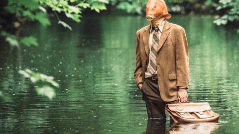 Un home-poisson en costume debout dans l'eau