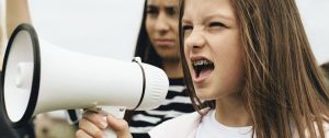 Jeune fille portant des bagues crie ans un mégaphone