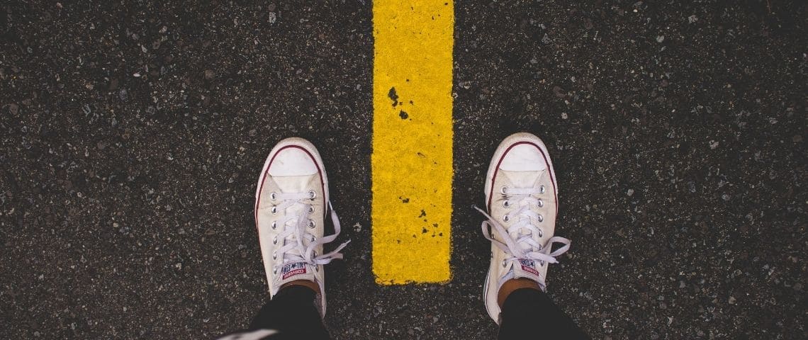 geosophy-outil-daudit-geo-energetique-energie-responsable-immobilier-sous-sol Des pieds. Chaussures : converses blanches. Bitume face une ligne de peinture jaune