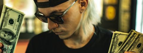 Pourquoi la pandémie de Covid a encouragé une pandémie de ransomwares ? Un homme blond tient des billets dans ses mains