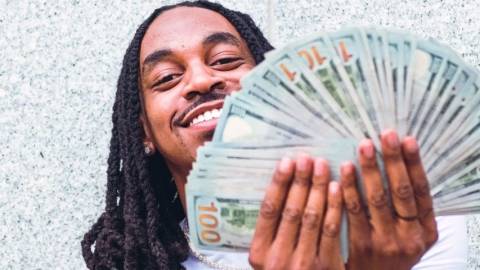 Un homme en train de tenir une liasse de billets