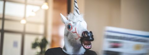 Que voir à Vivatech cette année ? Un homme en masque licorne lit le journal