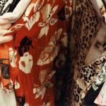 Une femme en train de regarder un portant de vêtements