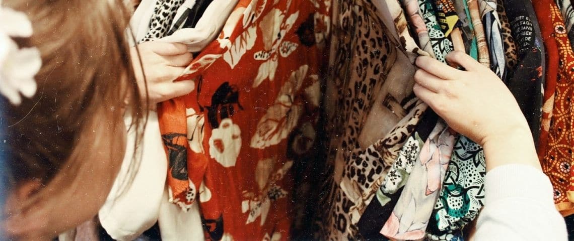 Comment rendre la mode éthique ? Une femme en train de regarder un portant de vêtements
