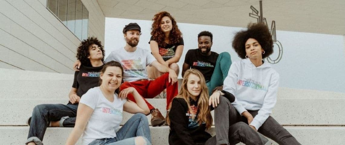 ONU Femmes France propose la vente d’articles solidaires dont les bénéfices seront reversés aux programmes d’ONU Femmes dans le monde Jeunes filles et garçons assis sur des marches d'escaliers