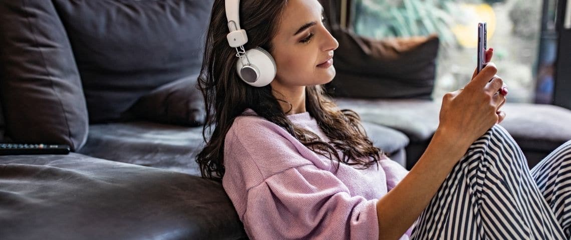 Huit façons d'optimiser vos podcasts pour qu'ils apparaissent dans Google Une femme qui écoute un podcast