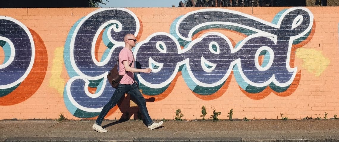 unify-partenaire-label-solidaire-whatrocks-foundation-publicite-solidaire-communication-engagement-nouvelle-consommation-sens Un homme qui marche dans la rue avec un - tag - écrit - good -