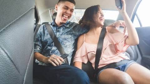 Deux jeunes adultes dans un Uber en train de prendre un selfie
