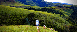 Randonneur sur colline dans un paysage naturel vaste et vert