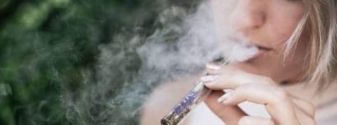 Comment Philip Morris veut faire en sorte que l'on arrête de fumer ? Une femme adulte en train de fumer une cigarette électronique