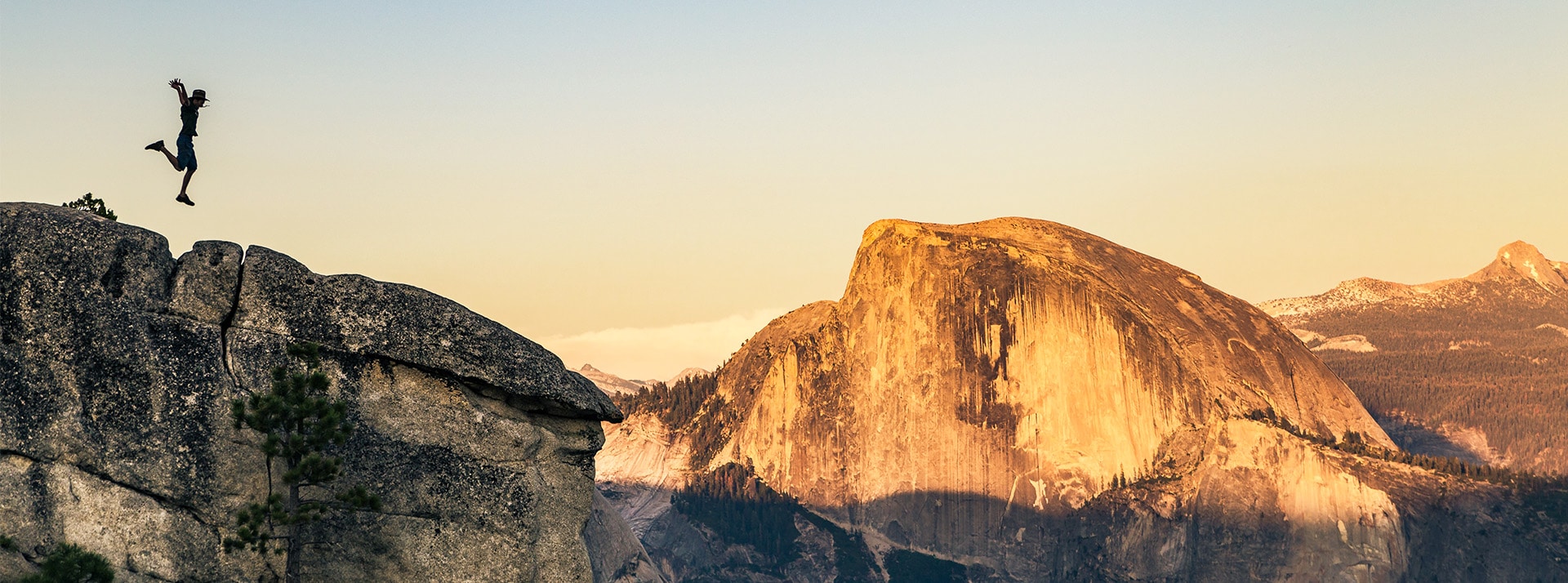 Homme sautant de joie au sommet d'une montagne