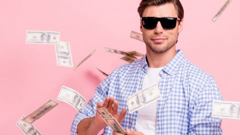 Trentenaire avec lunettes de solein et pluie de billets sur fond rose