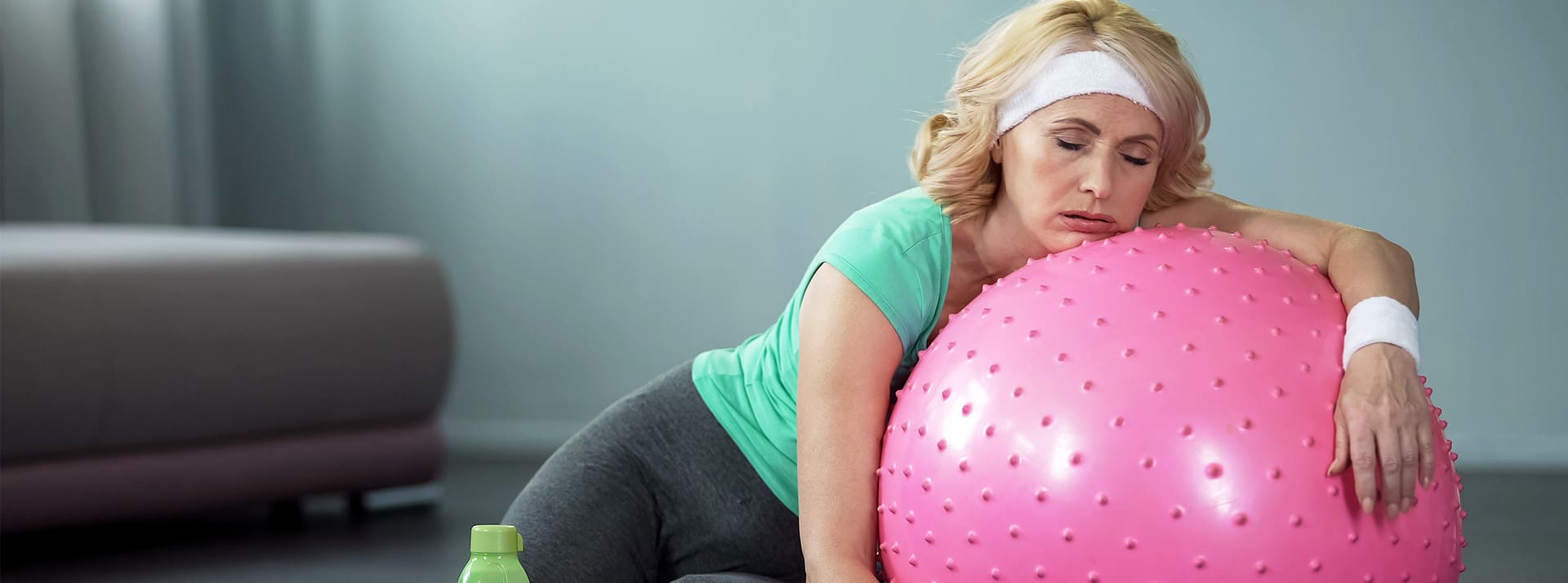 Motortion Femme d'environ 50 ans épuisée sur son ballon de sport