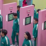 Des hommes et femmes coréens habillés en vert passent au travers de portiques rose